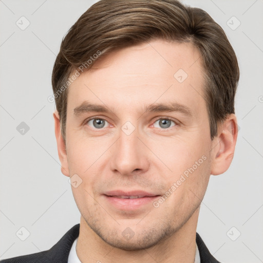 Joyful white young-adult male with short  brown hair and grey eyes