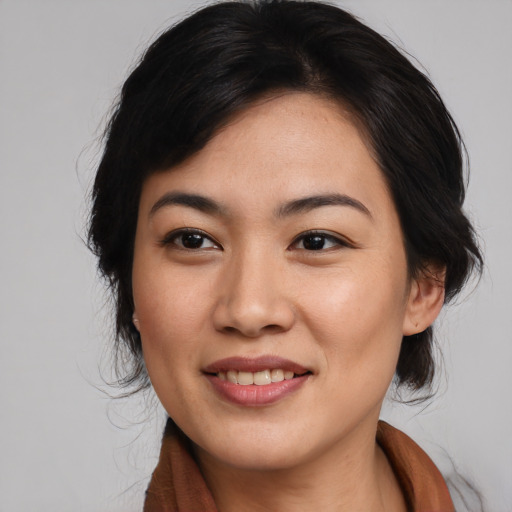 Joyful asian young-adult female with medium  black hair and brown eyes