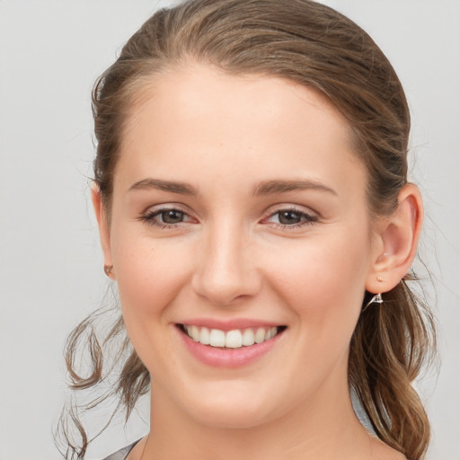 Joyful white young-adult female with medium  brown hair and grey eyes