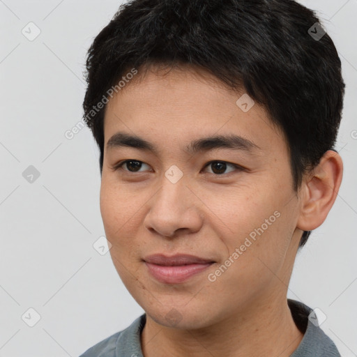 Joyful asian young-adult male with short  brown hair and brown eyes
