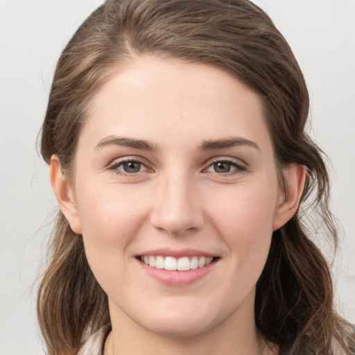 Joyful white young-adult female with medium  brown hair and grey eyes