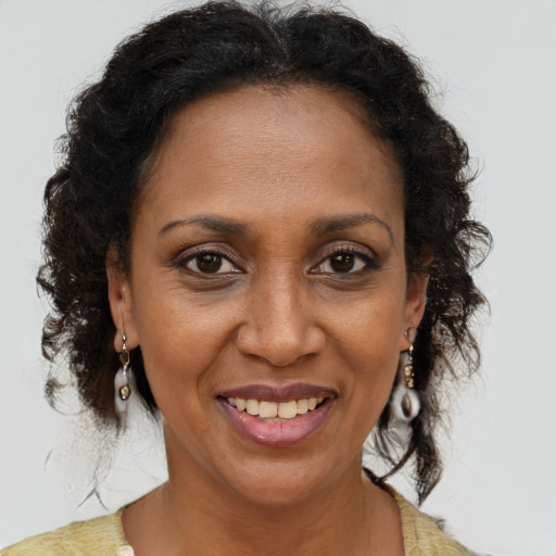Joyful black adult female with long  brown hair and brown eyes