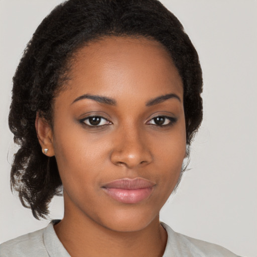 Joyful black young-adult female with long  brown hair and brown eyes