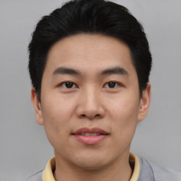 Joyful asian young-adult male with short  black hair and brown eyes