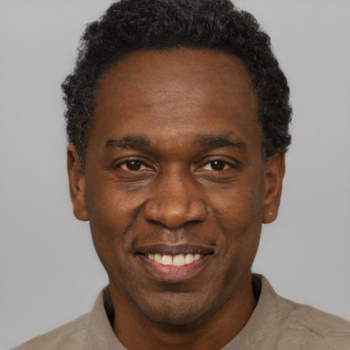Joyful black adult male with short  black hair and brown eyes