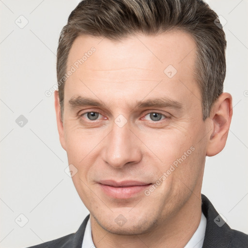 Joyful white adult male with short  brown hair and brown eyes