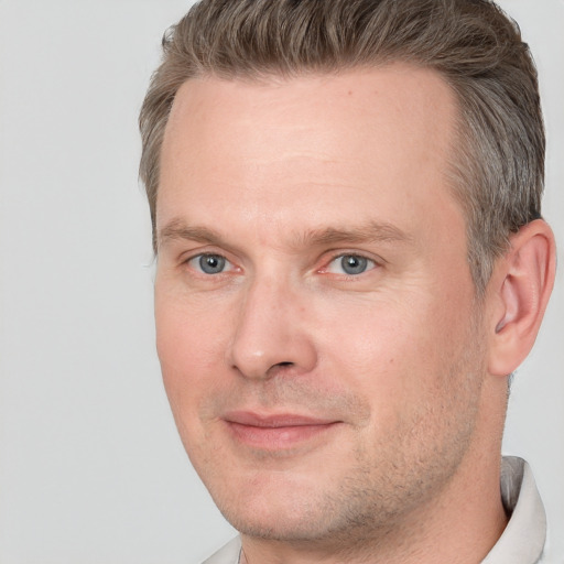 Joyful white adult male with short  brown hair and brown eyes