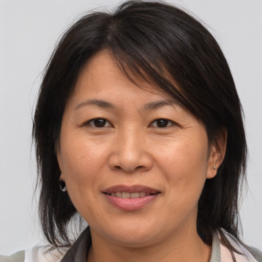 Joyful asian adult female with medium  brown hair and brown eyes