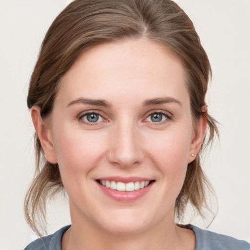 Joyful white young-adult female with medium  brown hair and grey eyes