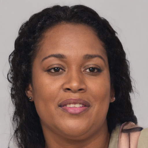 Joyful black adult female with long  brown hair and brown eyes