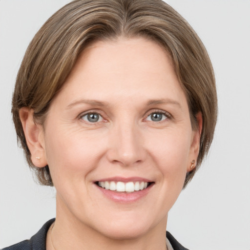 Joyful white adult female with medium  brown hair and grey eyes