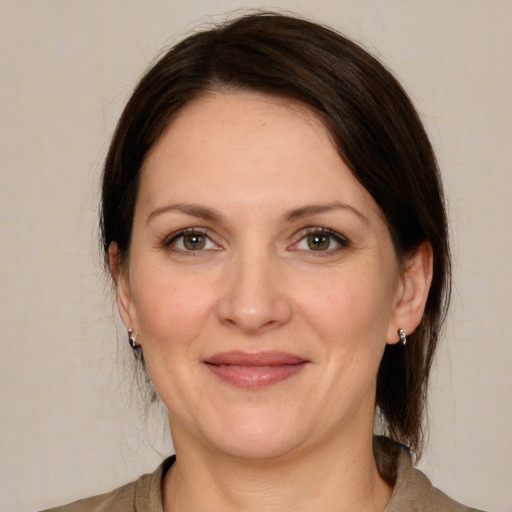 Joyful white adult female with medium  brown hair and grey eyes