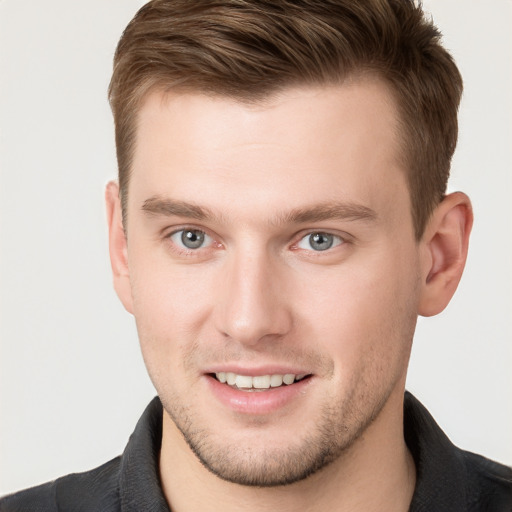 Joyful white young-adult male with short  brown hair and grey eyes