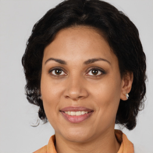 Joyful latino adult female with medium  brown hair and brown eyes