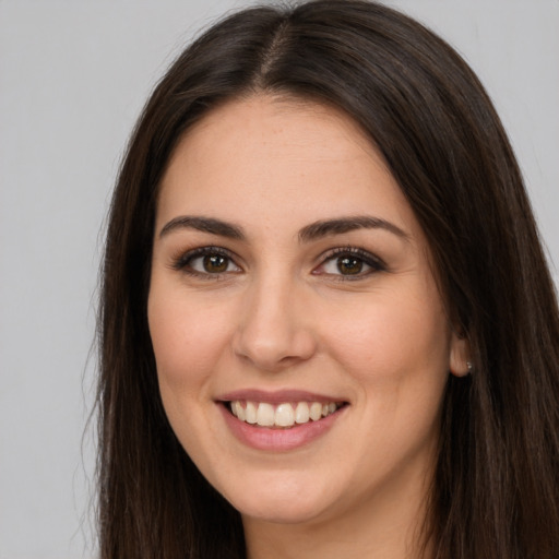 Joyful white young-adult female with long  brown hair and brown eyes