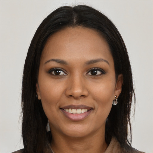 Joyful black young-adult female with long  brown hair and brown eyes
