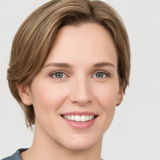 Joyful white young-adult female with medium  brown hair and grey eyes