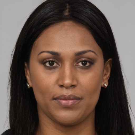 Joyful black young-adult female with long  brown hair and brown eyes