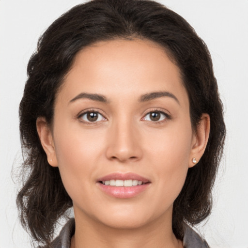 Joyful white young-adult female with long  brown hair and brown eyes