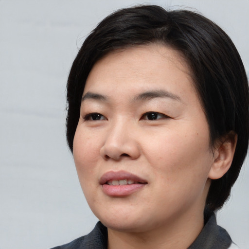 Joyful asian young-adult female with medium  black hair and brown eyes