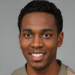 Joyful black young-adult male with short  black hair and brown eyes