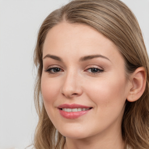 Joyful white young-adult female with long  brown hair and blue eyes