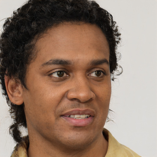 Joyful black young-adult male with short  brown hair and brown eyes