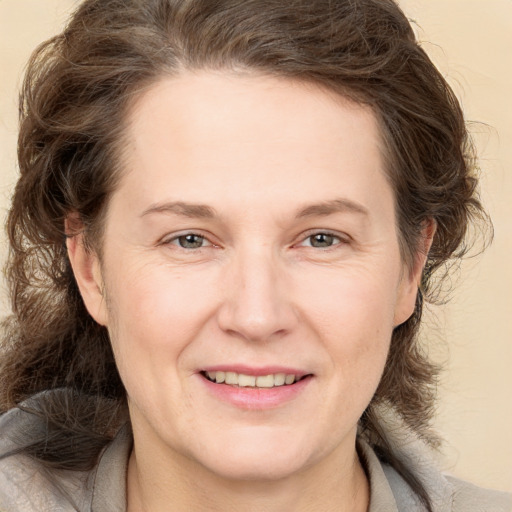 Joyful white adult female with medium  brown hair and brown eyes