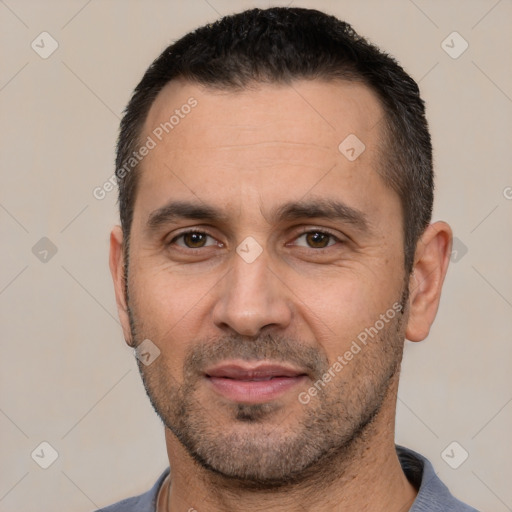 Joyful white adult male with short  black hair and brown eyes