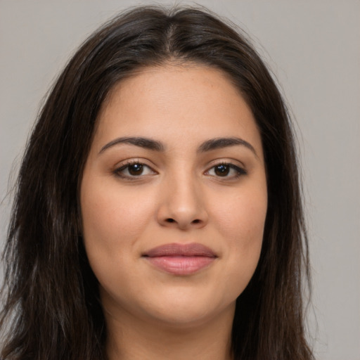 Joyful latino young-adult female with long  brown hair and brown eyes