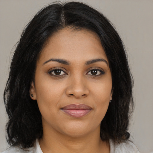 Joyful black young-adult female with medium  brown hair and brown eyes