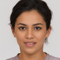 Joyful latino young-adult female with medium  brown hair and brown eyes