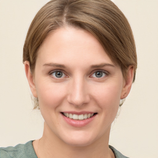 Joyful white young-adult female with medium  brown hair and grey eyes