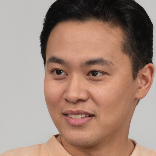 Joyful asian young-adult male with short  brown hair and brown eyes