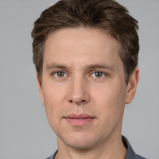 Joyful white adult male with short  brown hair and grey eyes