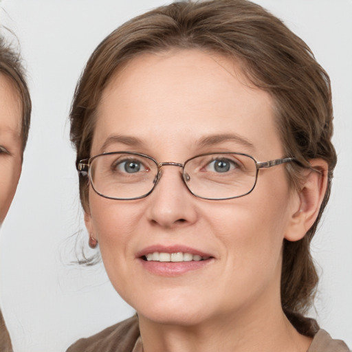 Joyful white adult female with medium  brown hair and grey eyes