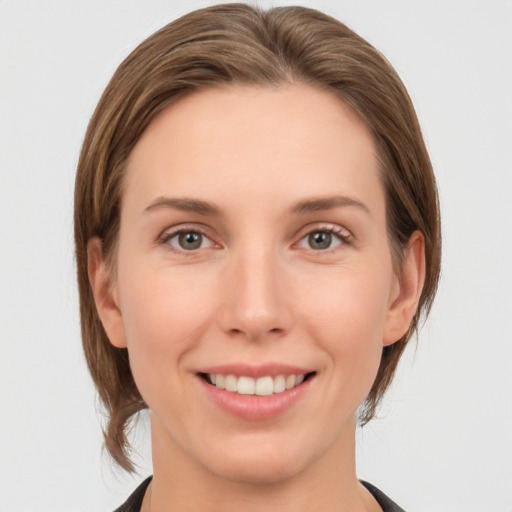 Joyful white young-adult female with medium  brown hair and grey eyes