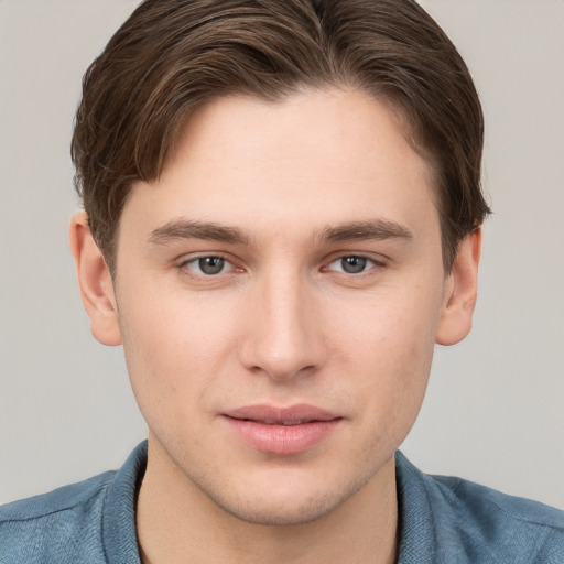 Joyful white young-adult male with short  brown hair and grey eyes