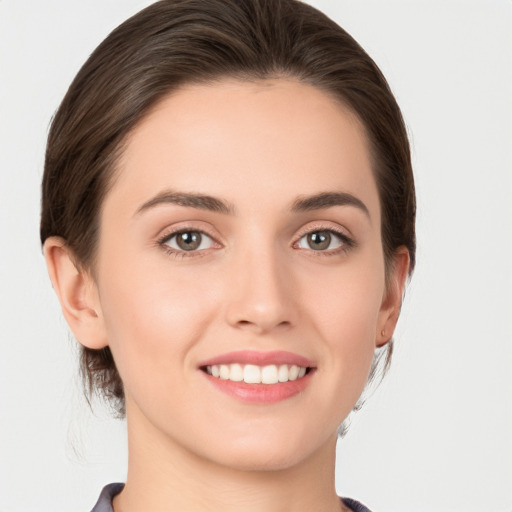 Joyful white young-adult female with medium  brown hair and grey eyes