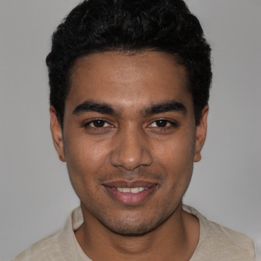 Joyful black young-adult male with short  black hair and brown eyes