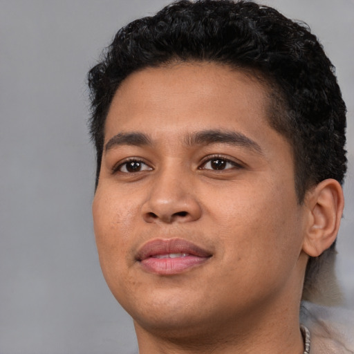 Joyful latino young-adult male with short  black hair and brown eyes