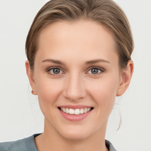 Joyful white young-adult female with medium  brown hair and grey eyes