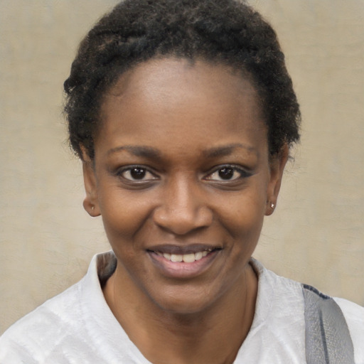 Joyful black young-adult female with short  black hair and brown eyes