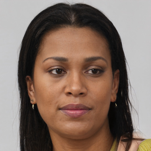 Joyful black adult female with long  brown hair and brown eyes