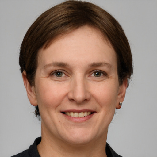 Joyful white adult female with short  brown hair and grey eyes