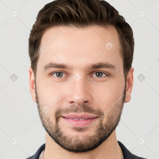 Joyful white young-adult male with short  brown hair and grey eyes