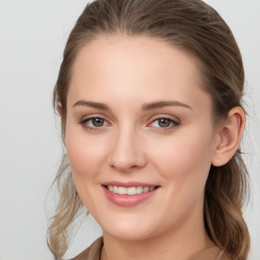 Joyful white young-adult female with long  brown hair and grey eyes