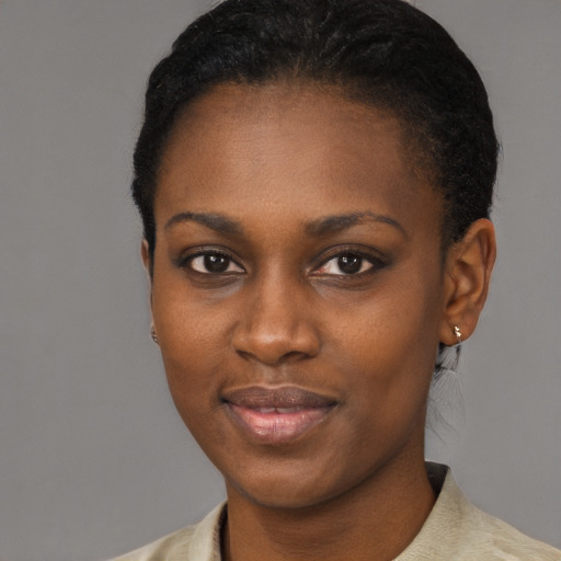 Joyful black young-adult female with short  black hair and brown eyes