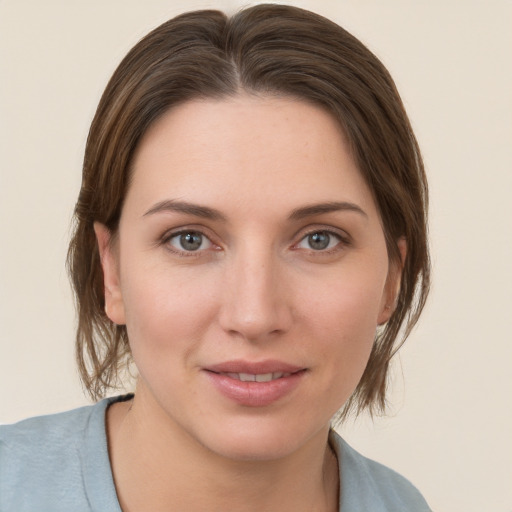 Joyful white young-adult female with medium  brown hair and grey eyes