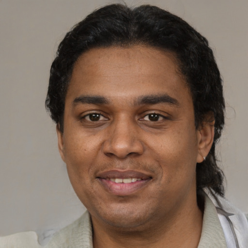 Joyful black adult male with short  black hair and brown eyes